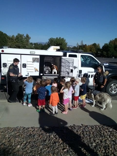 Preschoolers look into the kennel compartments of an Animal Control truck