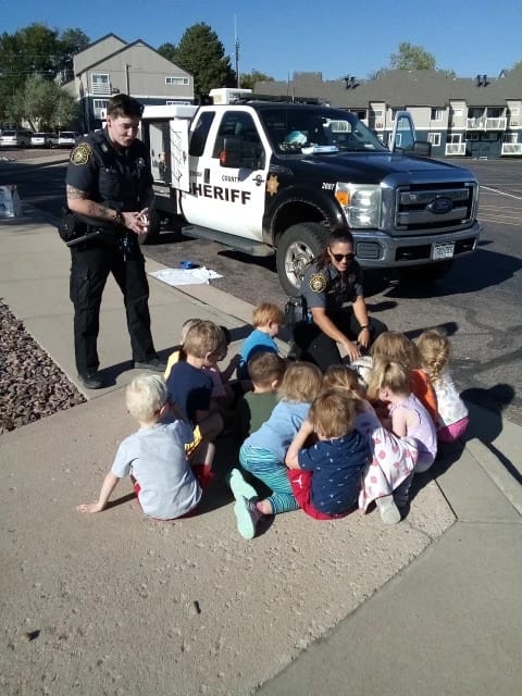 Animal Control officers show their truck and equipment to a group of preschoolers
