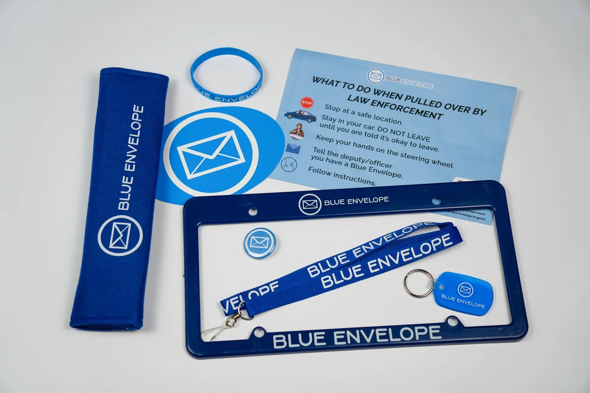 All Blue Envelope Program items including envelope, lanyard, seatbelt cover, button, key chain, bracelet, and bumper sticker