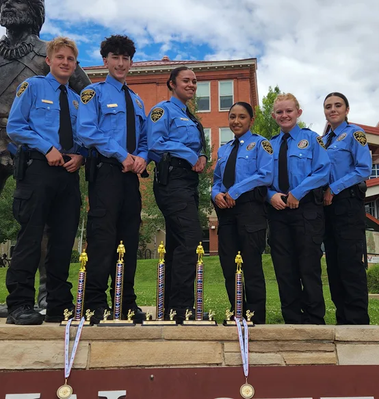 Six Explorer Post 99 members in uniform posing with their trophies and medals.