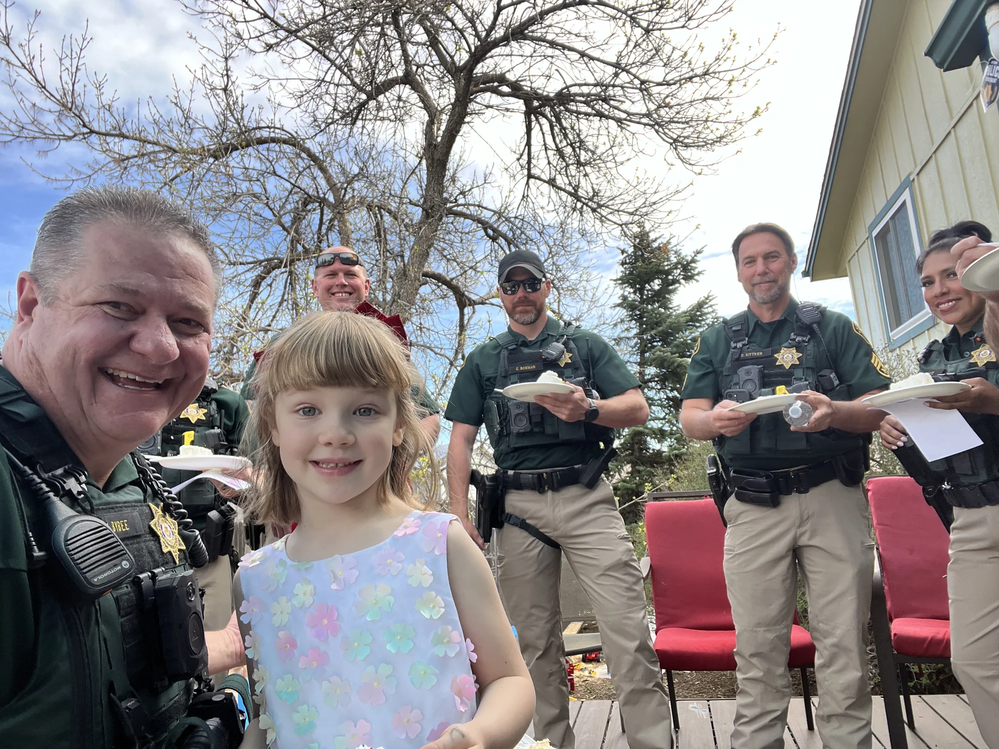 Community Resource Deputy Mark Bybee with deputies and a young child during a community visit