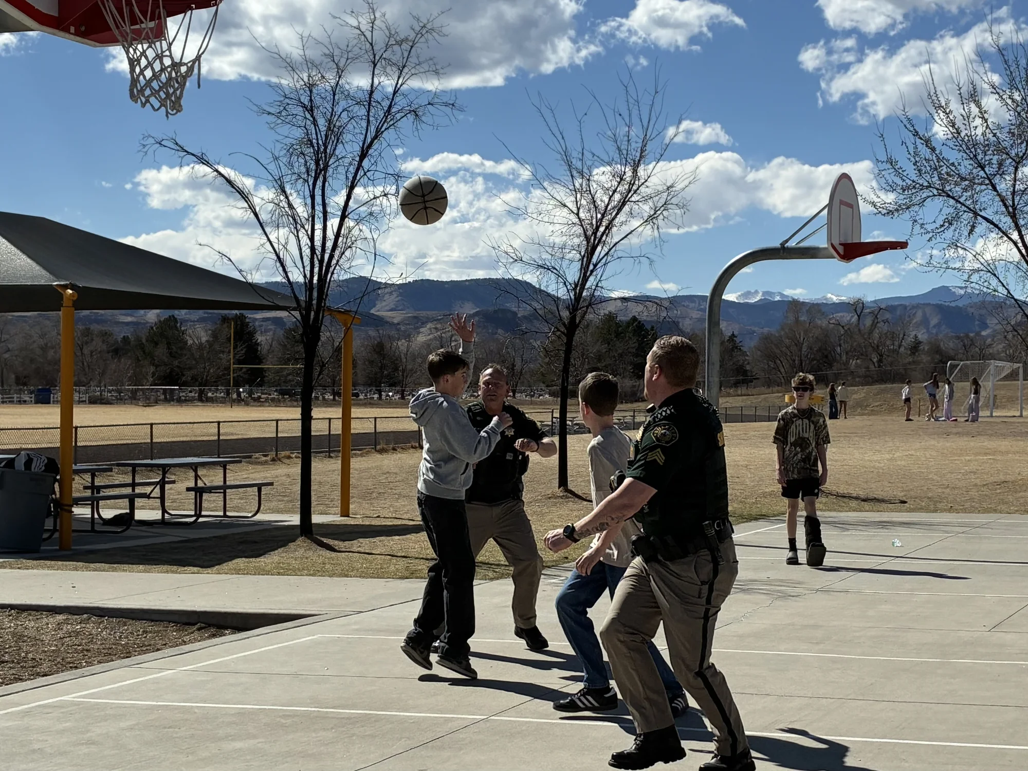 Sergeants Smoker and Rhoads playing basketball with Drake Middle School students at lunch during a career fair