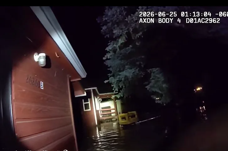 Body camera still of a deputy checking on a home surrounded by floodwater during the June 25 Bear Creek flooding