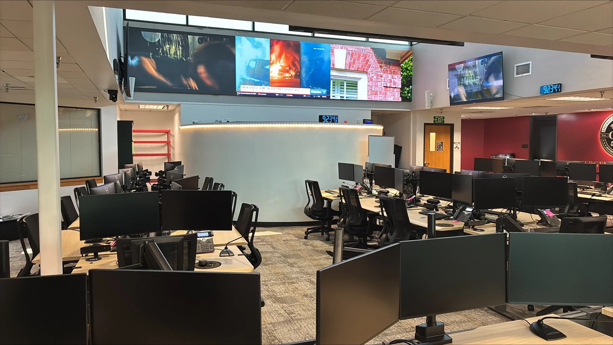 The Jefferson County Emergency Operations Center with rows of dual-monitor workstations and a large video wall showing live incident coverage